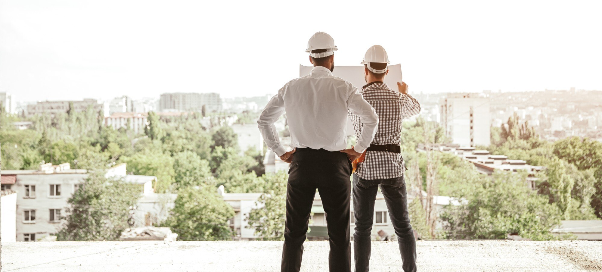 ANTONIO RULL CAPLLOCH -  - back view male architects hardhats examining blueprint discussing construction project while standin